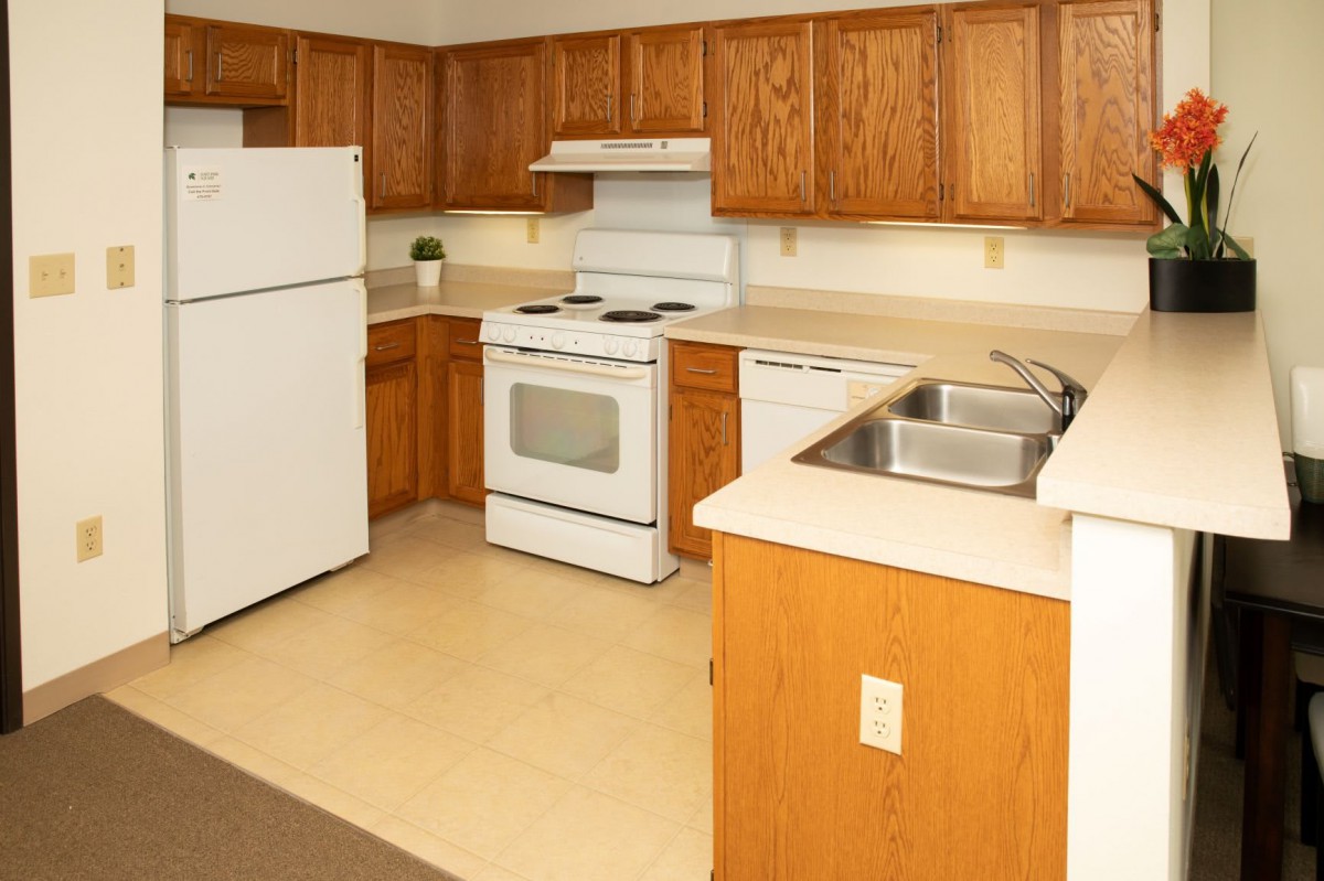 A cozy kitchen with wooden cabinets and standard appliances.
