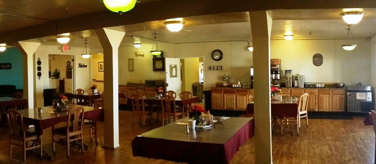 A cozy restaurant interior featuring a dining area with tables and chairs.