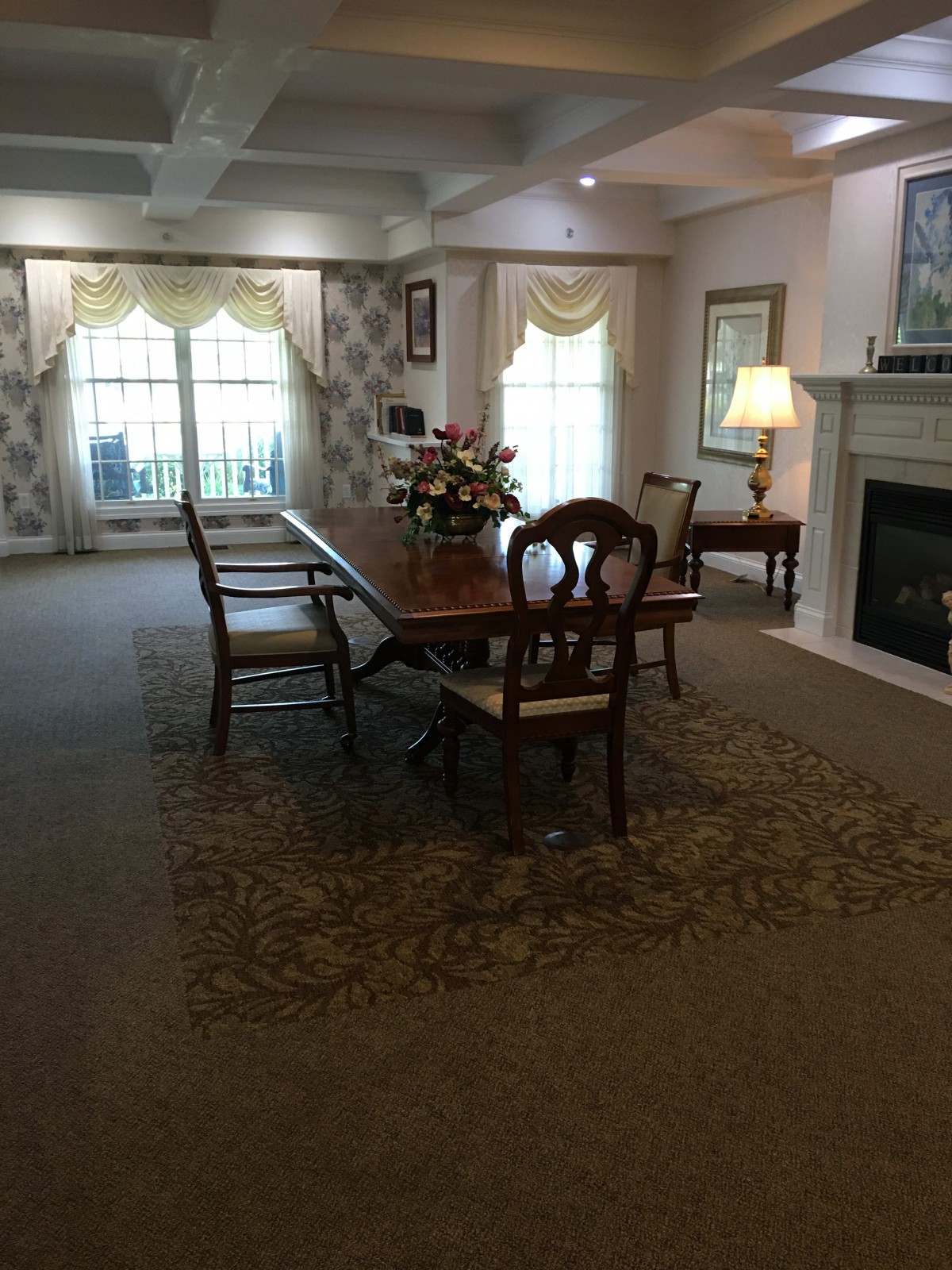 A cozy dining room with a wooden table, chairs, and a fireplace.