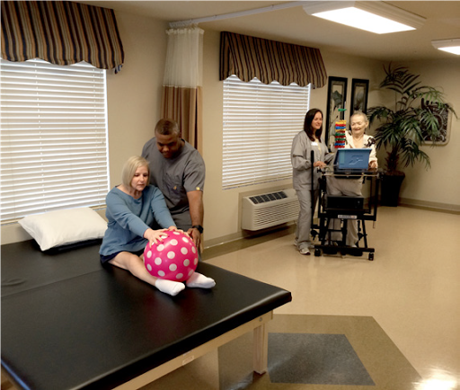 A physical therapy session in a healthcare facility, focusing on patient rehabilitation using a therapy ball.