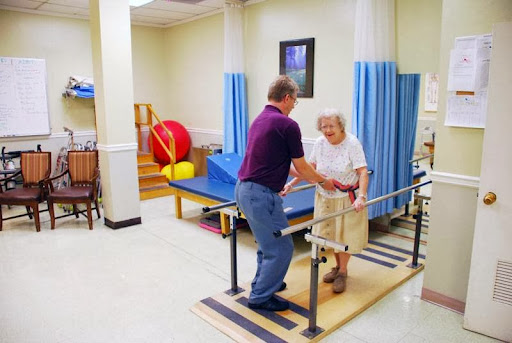 A physical therapist assists an elderly woman during a rehabilitation session.