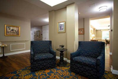 A cozy lobby seating area with two patterned chairs and a small table.