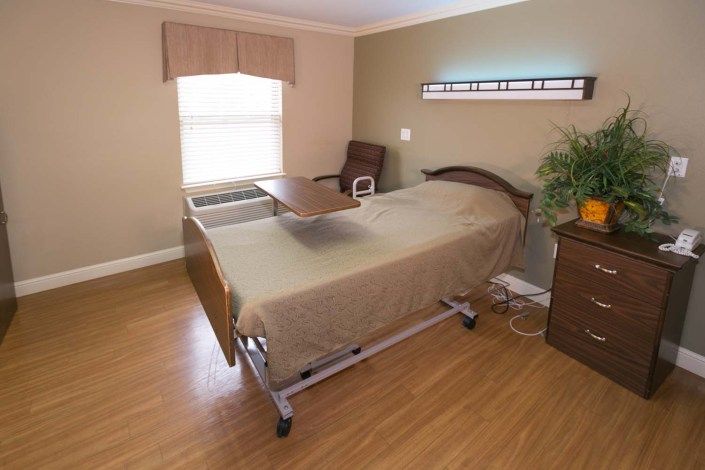 A hospital room featuring a single bed with medical equipment and furnishings.