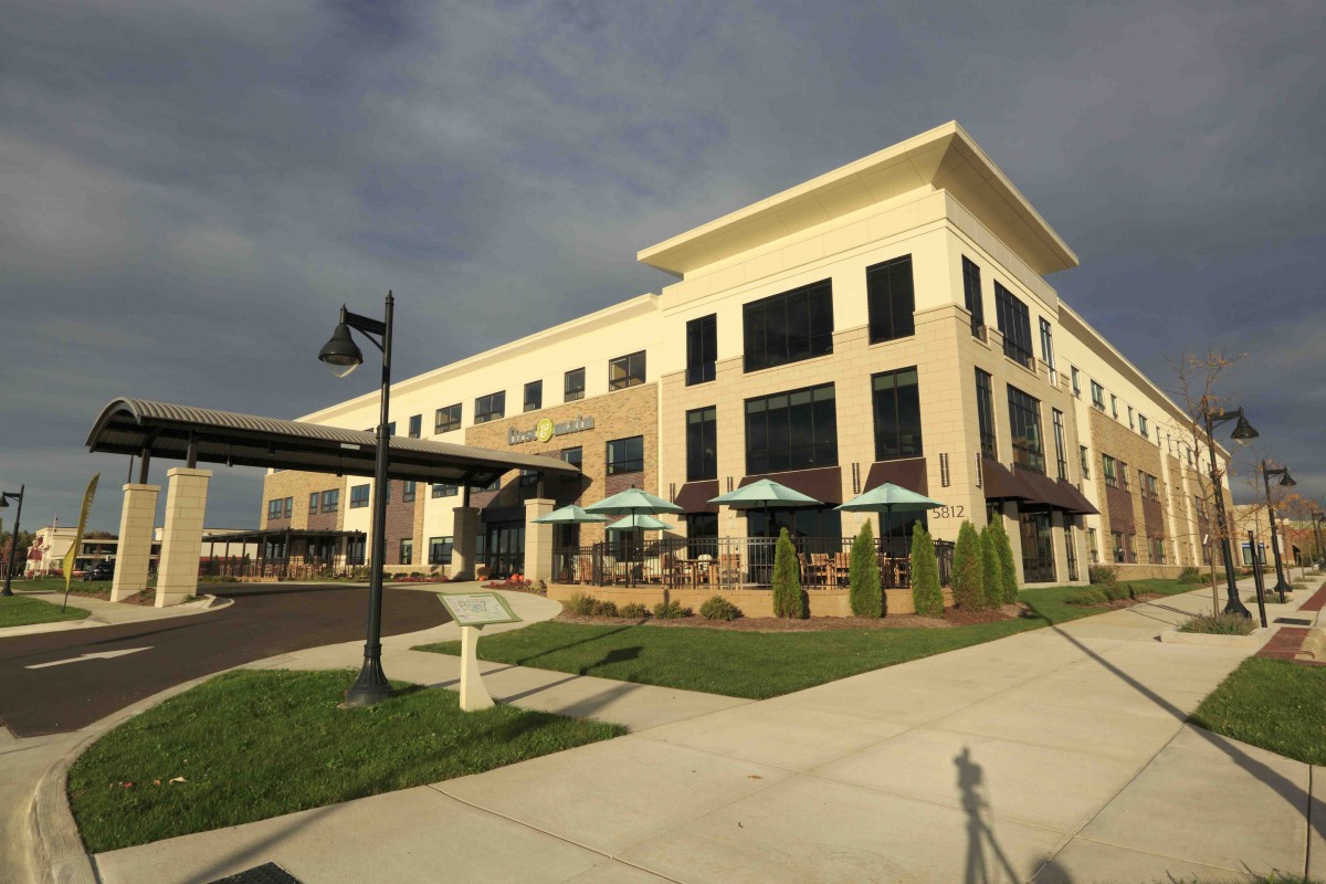 A modern restaurant with outdoor seating under a cloudy sky.
