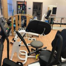 A gym with various exercise machines and fitness equipment.