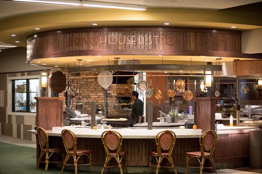 A cozy restaurant kitchen with a welcoming dining counter and staff preparing meals.
