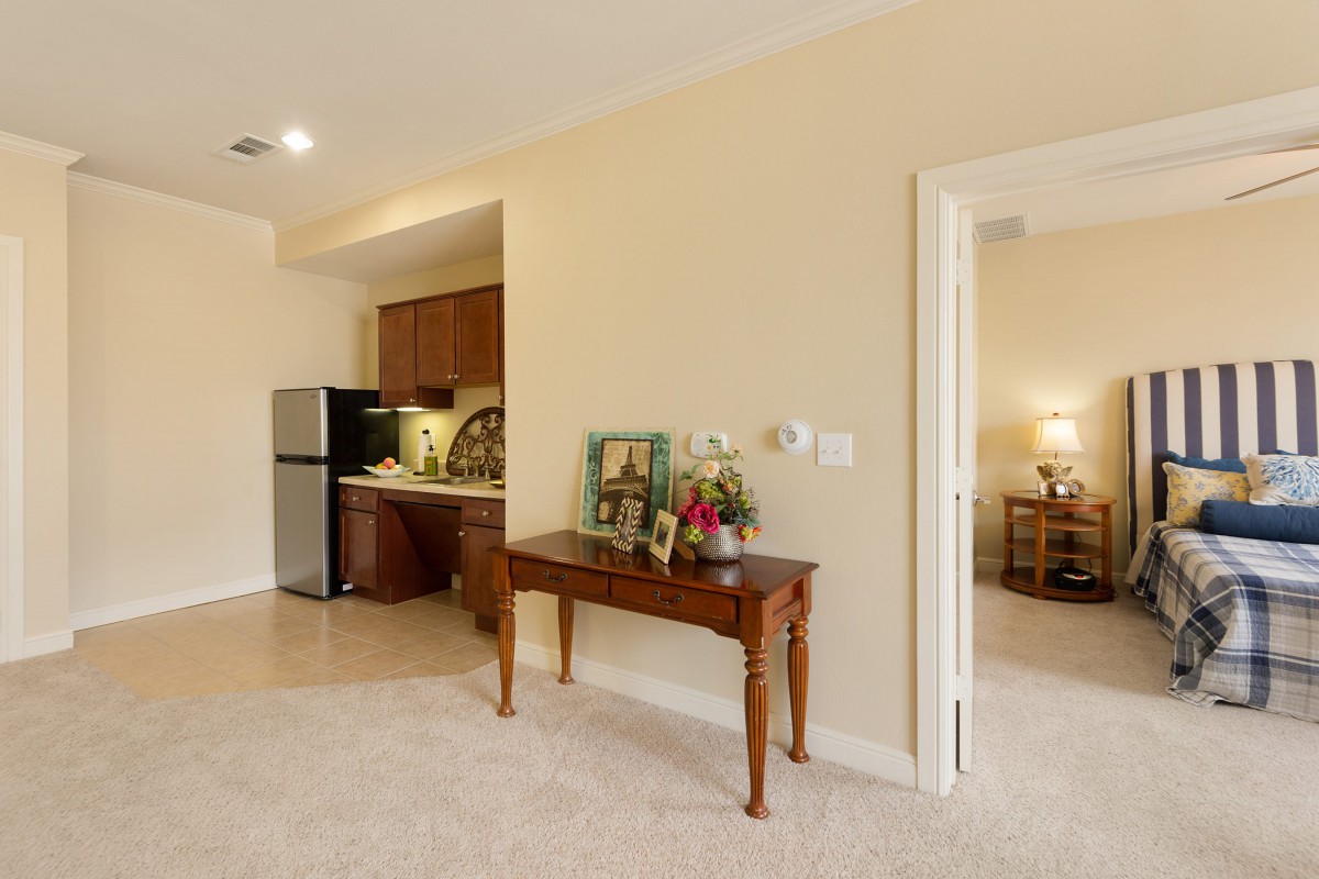 A cozy living space featuring a small kitchen area, decorated table, and an open doorway leading to another room.