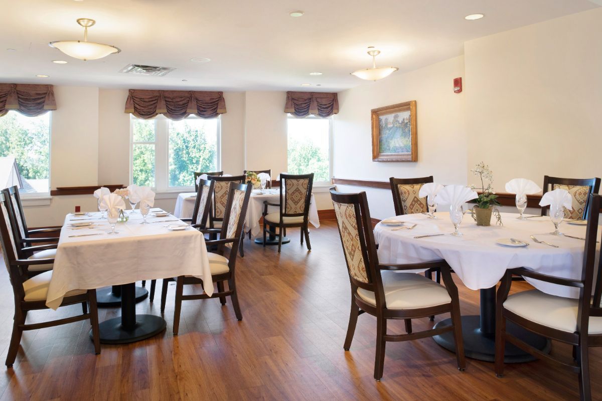 An elegant dining room with neatly set tables and comfortable chairs.
