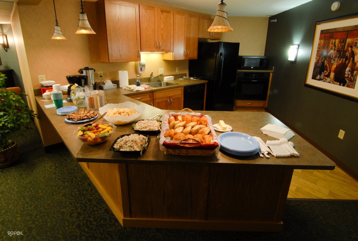 A kitchen counter set up with a variety of snacks and dishes, ready for a party or gathering.
