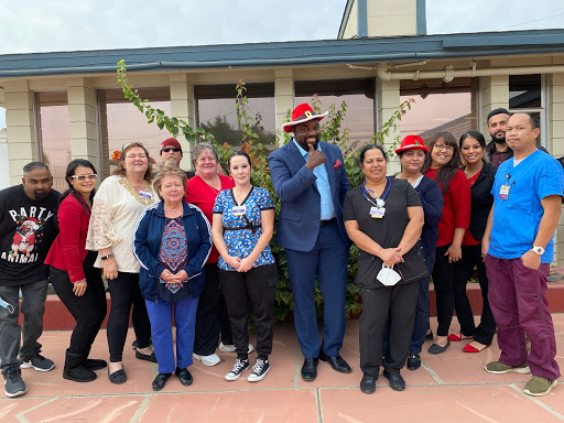 A cheerful gathering of community members dressed in red and blue, celebrating together outdoors.