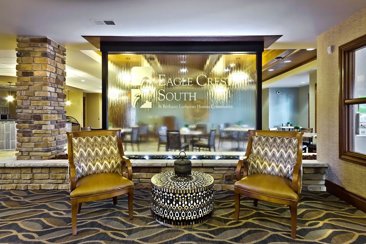 A hotel lobby with stylish chairs and a central table.