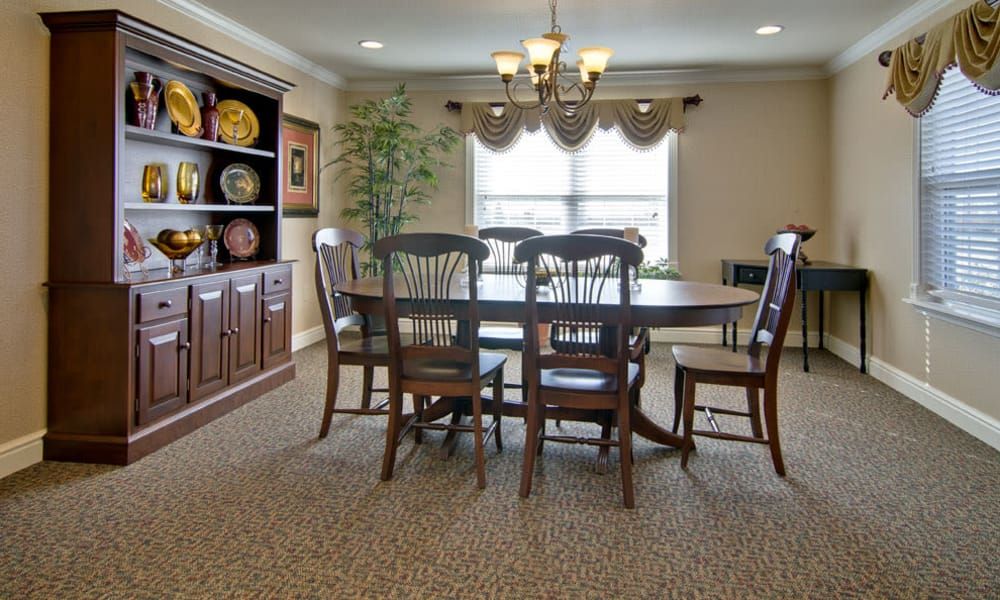 A dining room with a wooden table and chairs, a chandelier, and decorative elements.