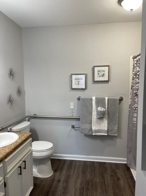 A neatly arranged bathroom with wall art and towels.