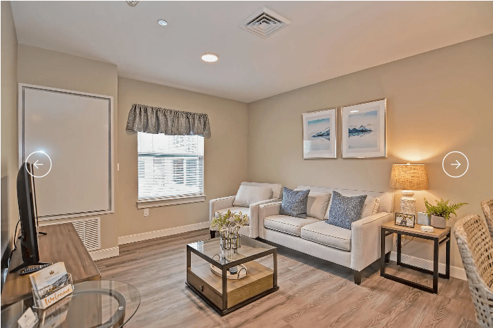 A cozy living room with a neutral color scheme, featuring a sofa, coffee table, and decorative elements.