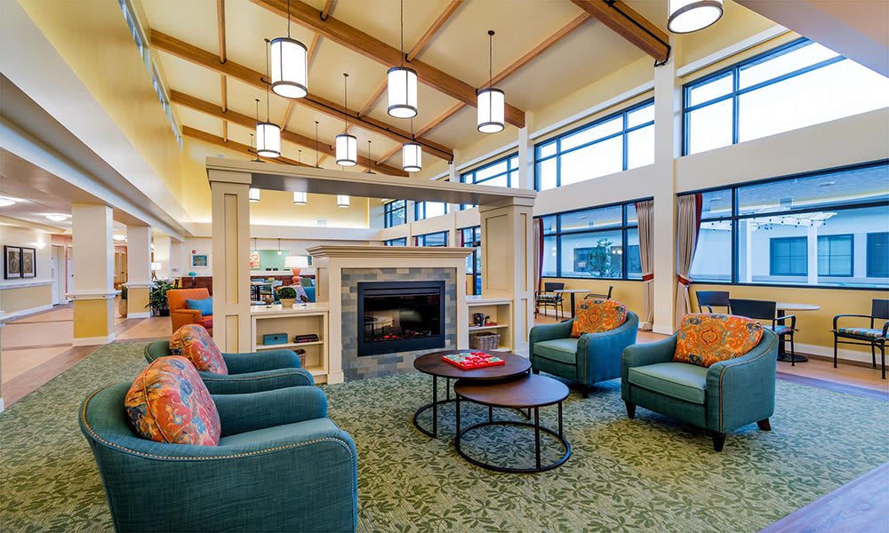 A cozy and modern living room with a fireplace, ample seating, and large windows.