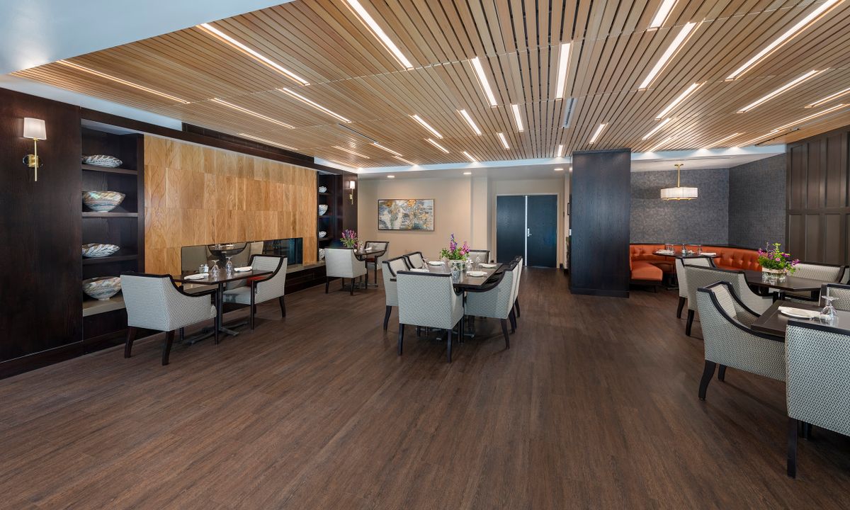 A modern dining area with wooden ceiling and elegant indoor seating arrangement.