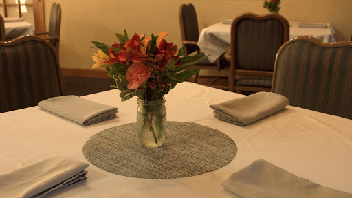 A beautifully arranged dining table featuring a vase of vibrant flowers.
