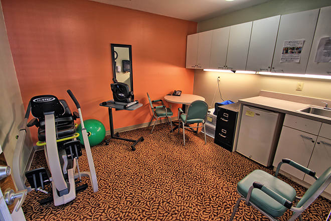 A rehabilitation room equipped with various medical and exercise equipment.