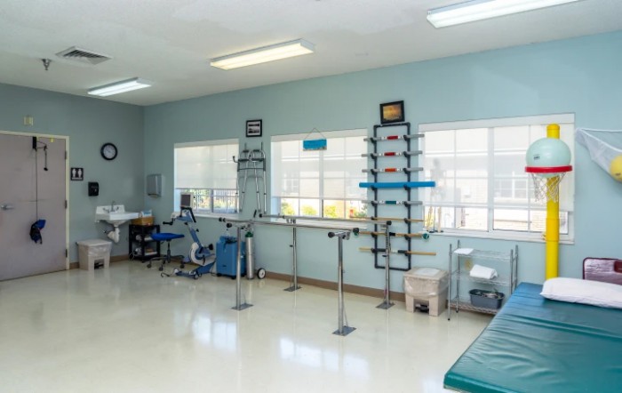 A well-equipped physical therapy and rehabilitation room featuring various exercise equipment.