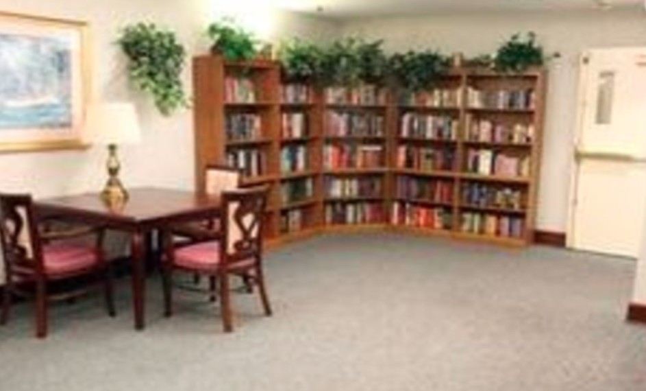 A cozy library corner with bookshelves, a table, and chairs.