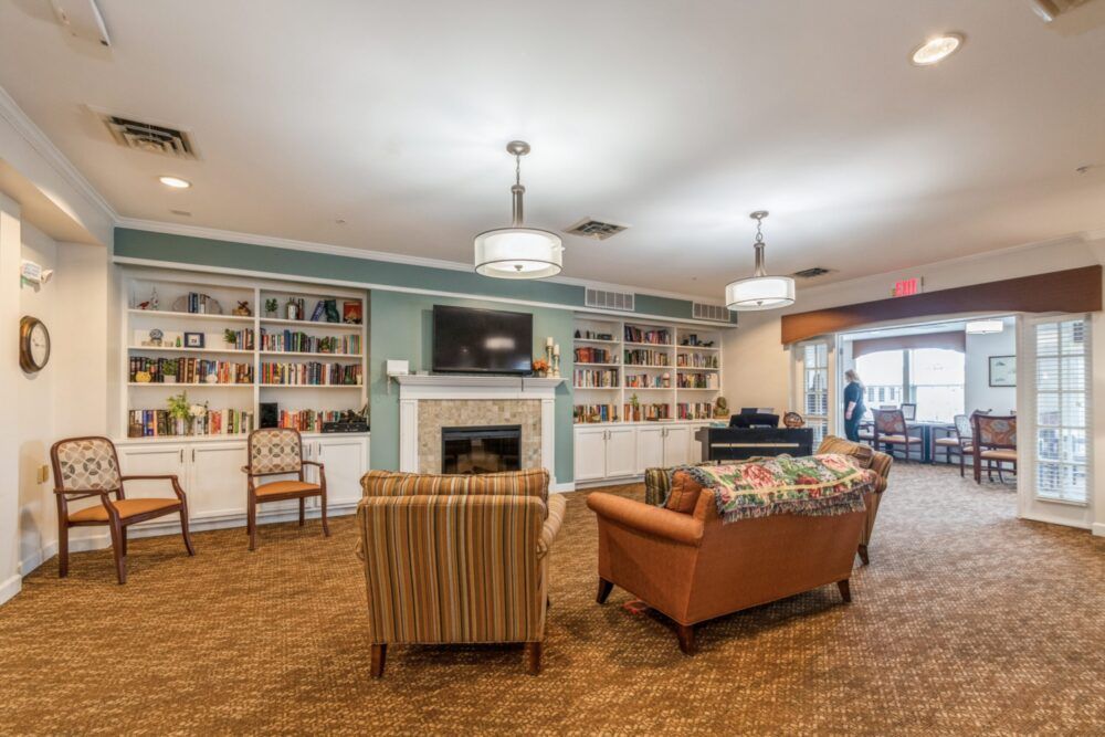 A cozy living room with a fireplace, television, and bookshelves.
