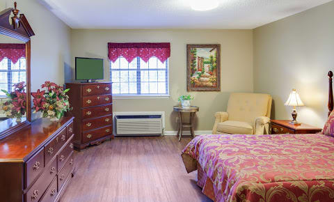 A cozy bedroom with a comfortable armchair, dresser, and decorative elements.