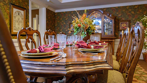 A beautifully set dining table with elegant tableware and a vibrant floral centerpiece.