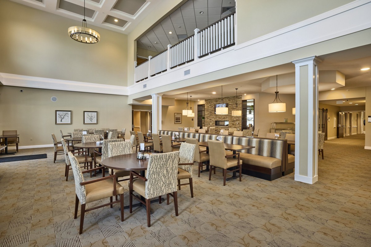 A spacious and elegantly designed dining area with modern furniture and lighting.