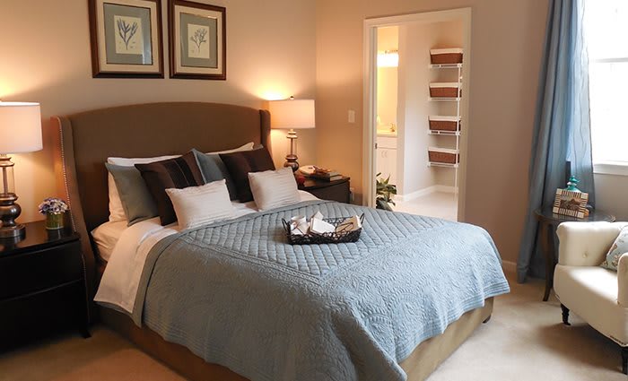 A cozy and well-decorated bedroom with a neatly made bed and soft lighting.