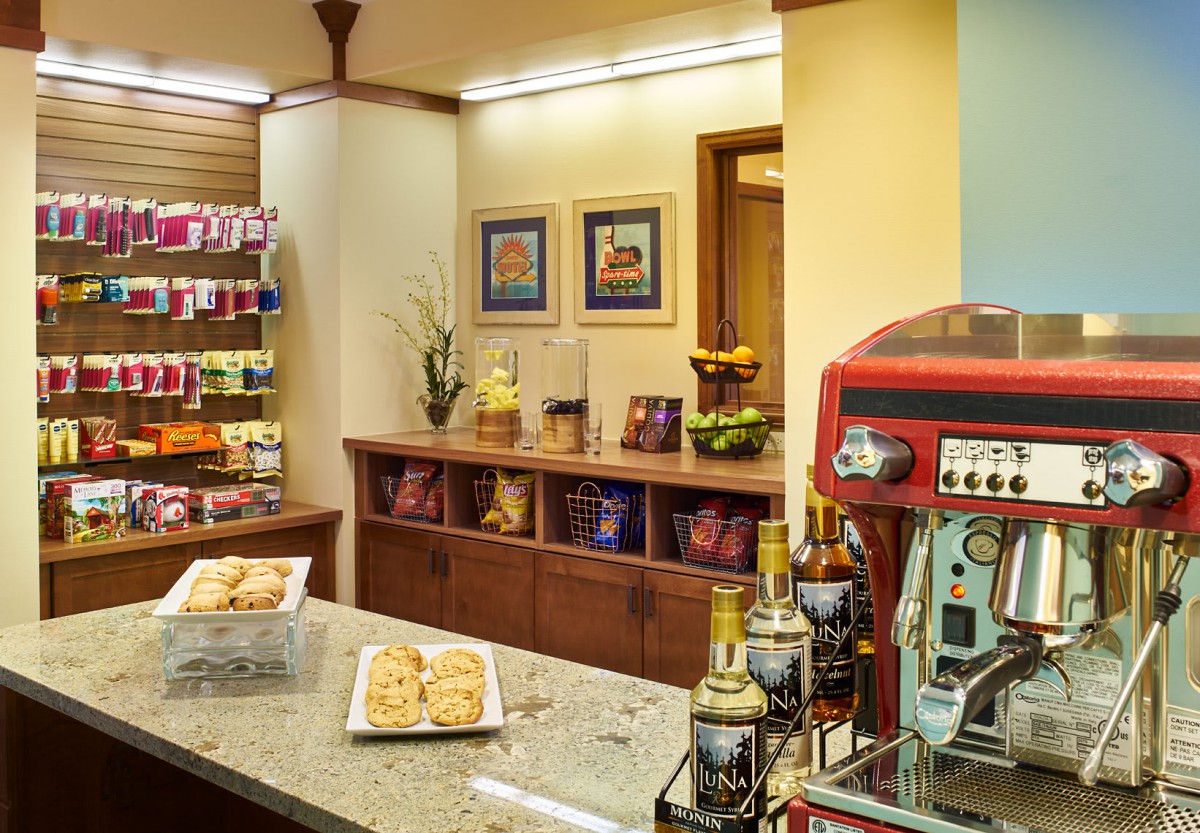 Cozy coffee shop corner with an espresso machine and snacks on display.