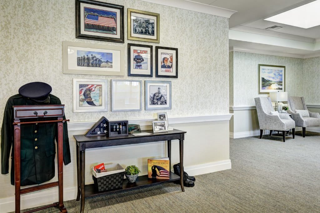 A cozy lobby area featuring framed artwork on the wall and a decorative table with various items.