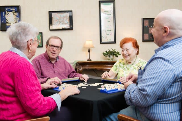 A group of seniors enjoying a tabletop game together indoors.
