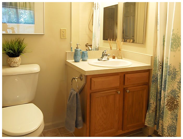 A cozy bathroom with a wooden vanity, sink, and mirror.