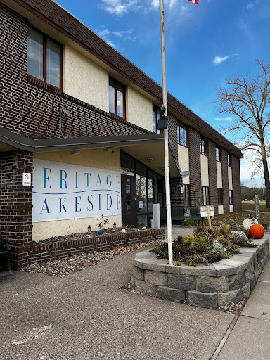 A view of a brick building featuring signage and landscaped surroundings.