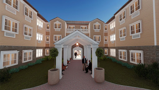 A beautifully designed residential building with a welcoming courtyard, illuminated in the evening light.