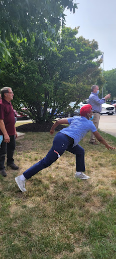 A group of men engaged in an outdoor throwing activity, capturing a dynamic moment.
