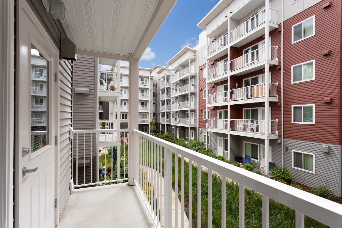 View from a balcony overlooking modern residential apartment buildings.