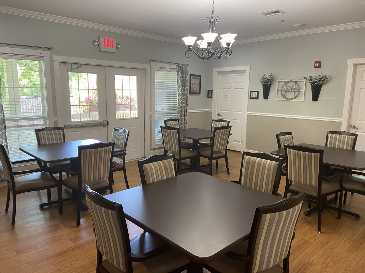 A well-lit dining area with multiple tables and chairs.