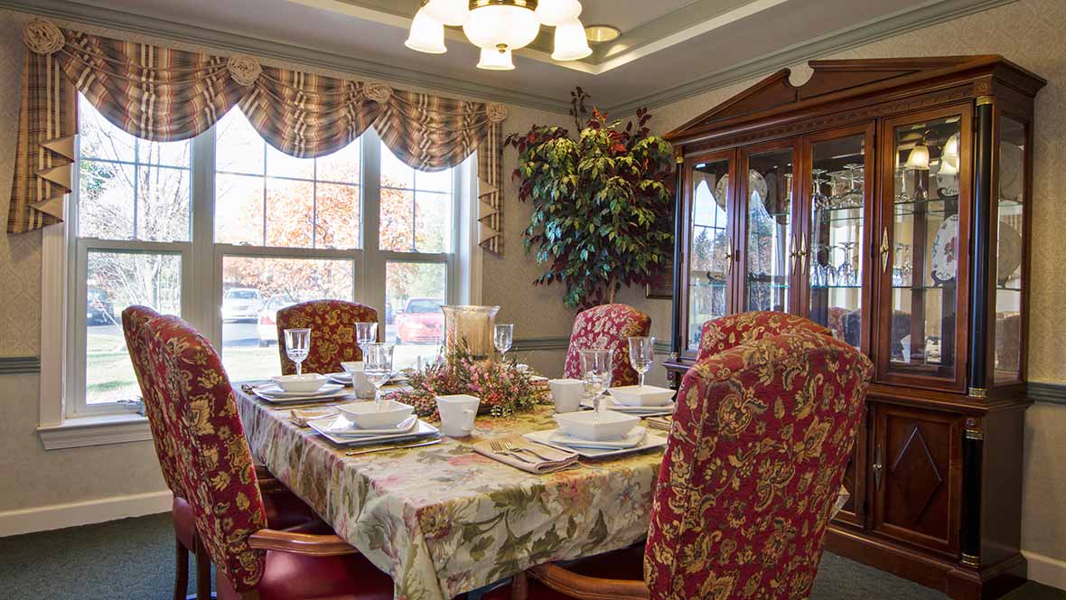 A beautifully set dining room table with ornate chairs and elegant dinnerware.