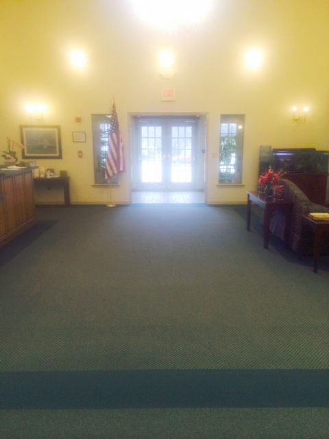 A spacious lobby area with seating, an American flag, and natural lighting.