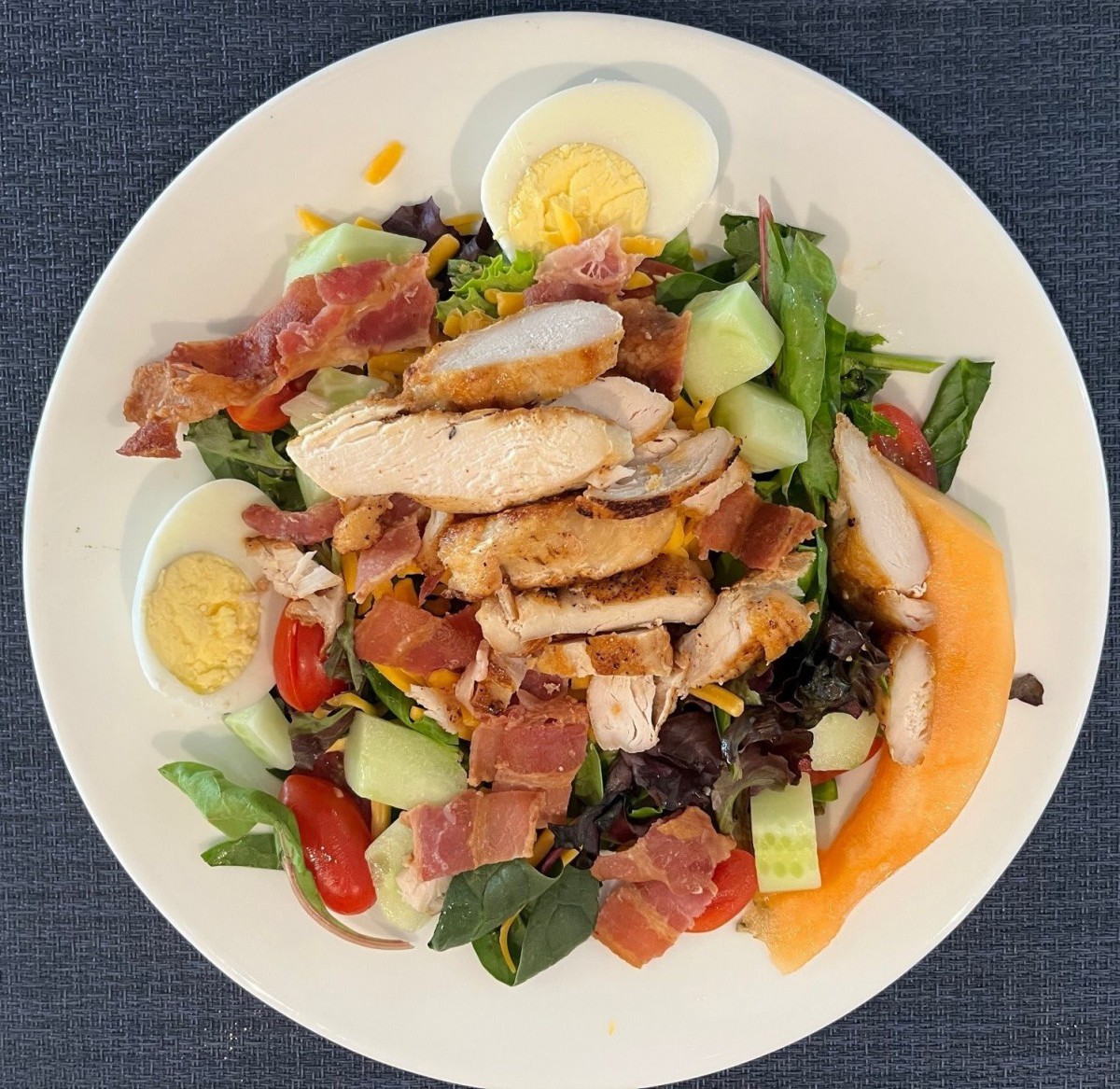 A delicious chicken salad with boiled eggs and fresh vegetables.