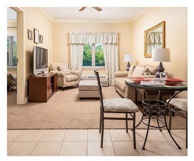 A cozy living room with a sofa, television, and dining area.