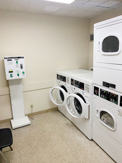 A laundry room with coin-operated washing machines and dryers.