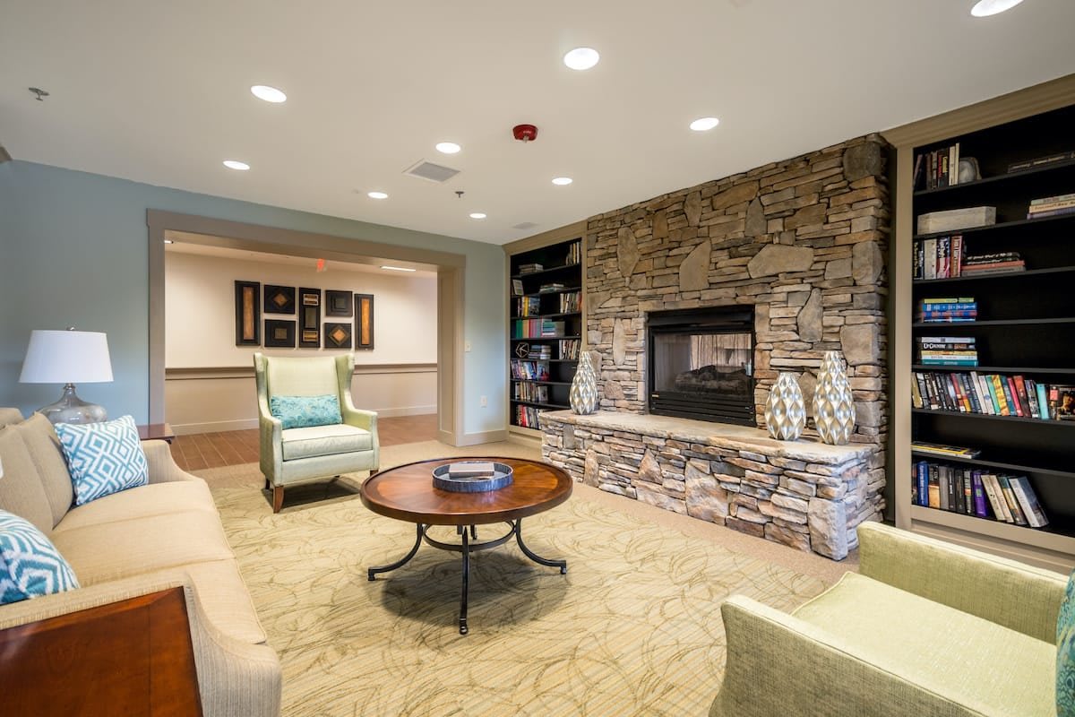 A cozy living room featuring a stone fireplace and comfortable seating arrangements.