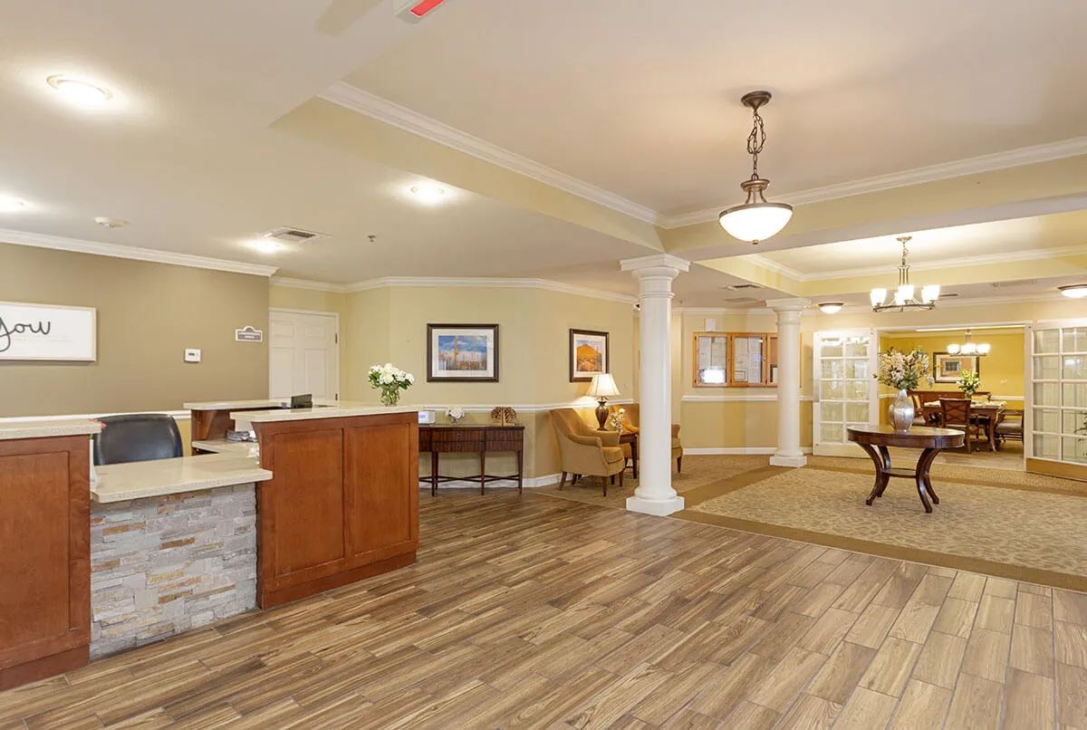 A modern reception area with wood flooring, a comfortable waiting space, and elegant lighting.