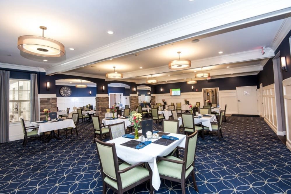 A spacious and elegantly decorated dining room with neatly arranged tables and chairs.