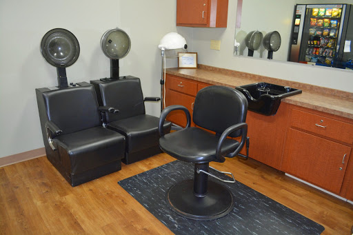 A modern hair salon setup featuring a styling chair, waiting area, and hair dryers.