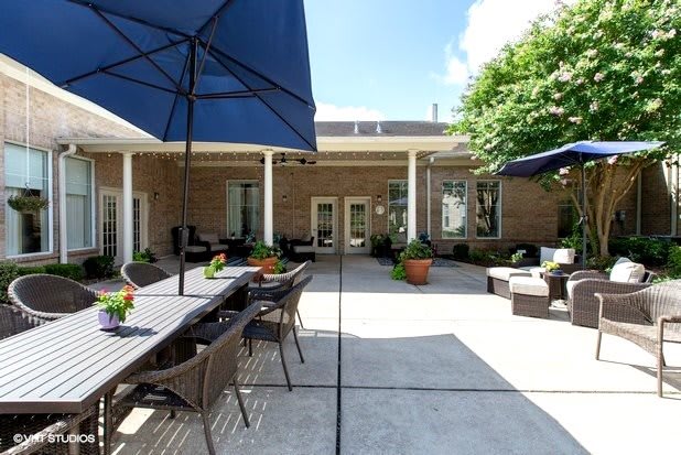 A spacious outdoor patio with seating and umbrellas on a sunny day.