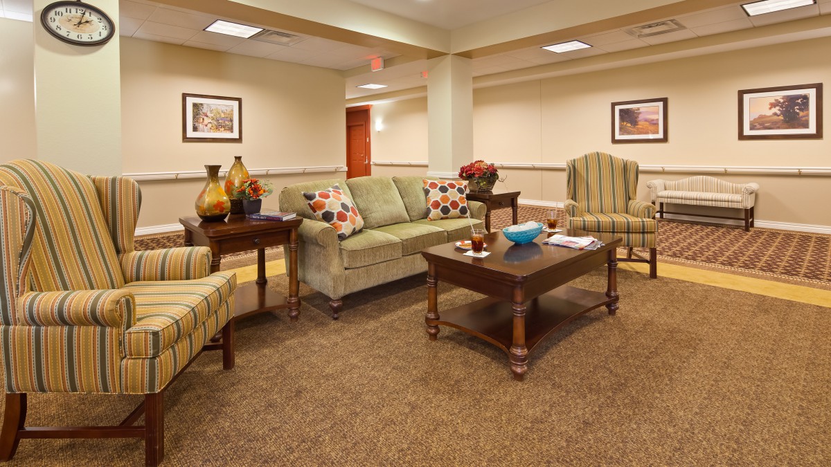 A cozy living room setup with a sofa, chairs, and a coffee table surrounded by warm decor.