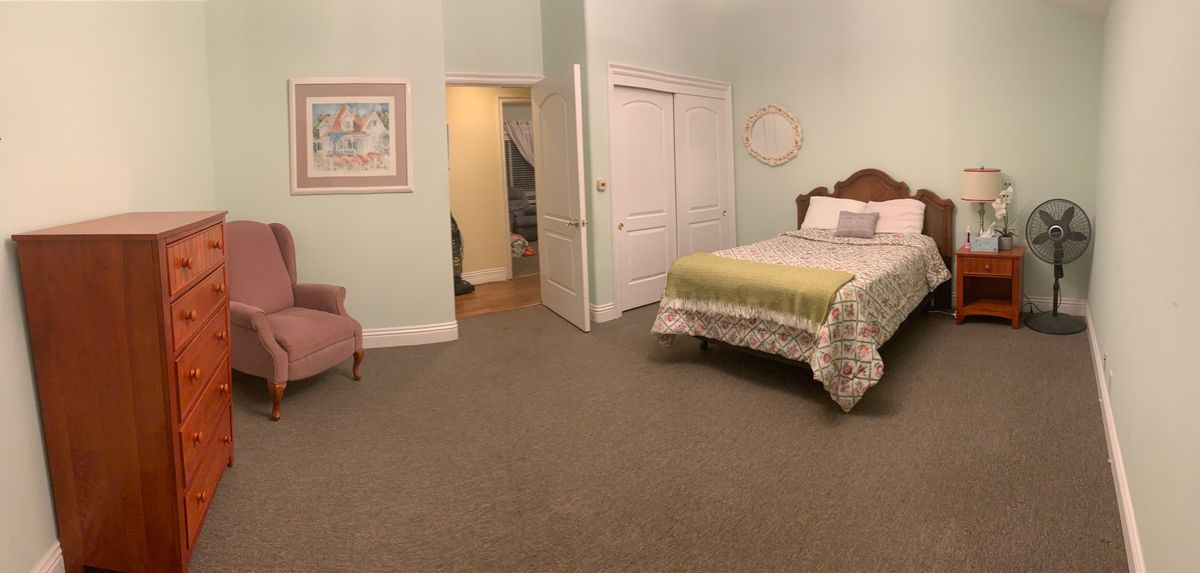 A cozy bedroom with a neatly made bed and comfortable seating.